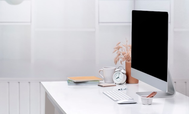 Maqueta de computadora de escritorio y suministros en la mesa superior blanca. Pantalla en blanco para diseño gráfico. Copie el espacio.