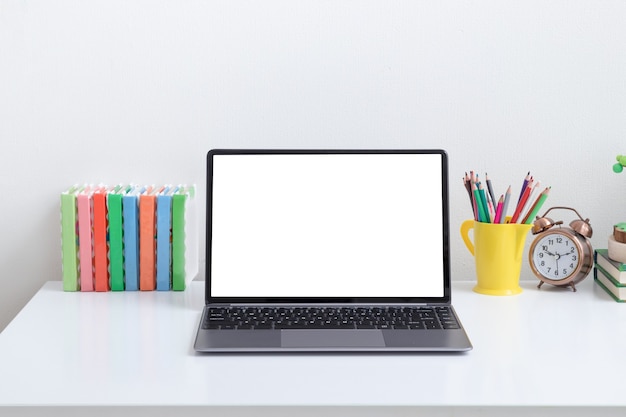 Maqueta de computadora portátil abierta en el lugar de trabajo de los niños con libros de colores y lápices aprendizaje en línea de regreso a la escuela ...