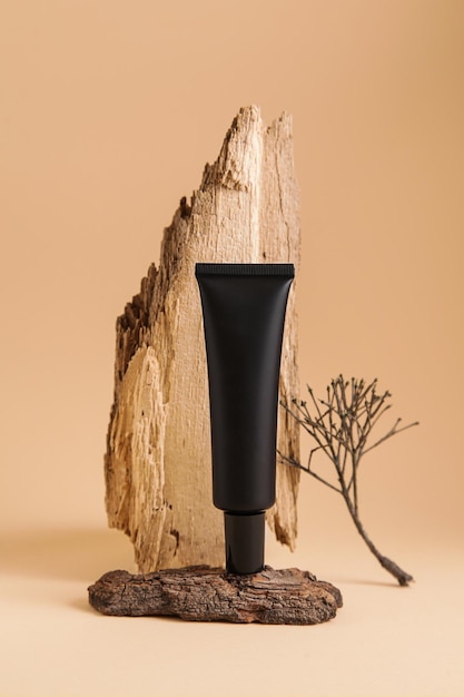 Maqueta cosmética tarro de crema negra en la corteza del árbol Concepto de cosmética natural fondo beige espacio de copia maqueta otoño