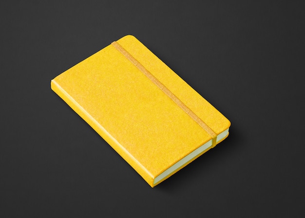 Maqueta de cuaderno cerrado amarillo aislado en negro