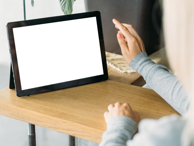 Maqueta digital mujer casual trabajo en línea mujer sentada escritorio desplazamiento tableta computadora pantalla en blanco