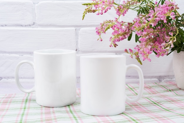 Maqueta de dos tazas de café con pequeñas flores rosadas