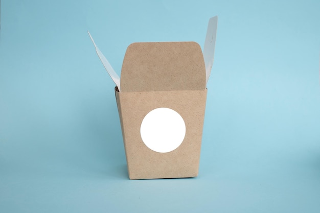 Maqueta de etiqueta redonda en caja de almuerzo de caja kraft abierta con etiqueta adhesiva en blanco