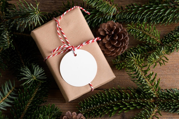 Maqueta de etiqueta de regalo de Navidad redonda en blanco con maqueta de etiqueta de producto de caja actual con rama de abeto natural