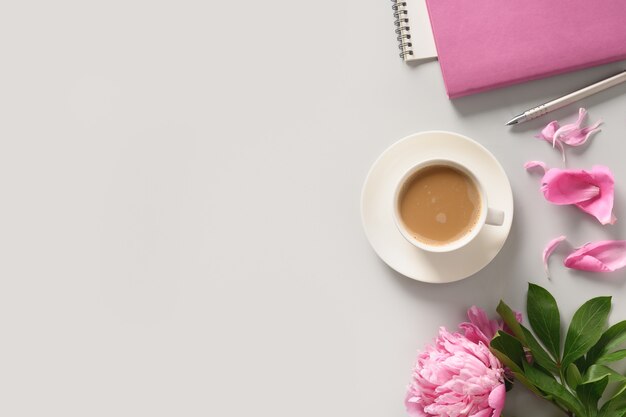 Maqueta femenina creativa con cuaderno de bocetos de flores de peonía de taza de café para planificación