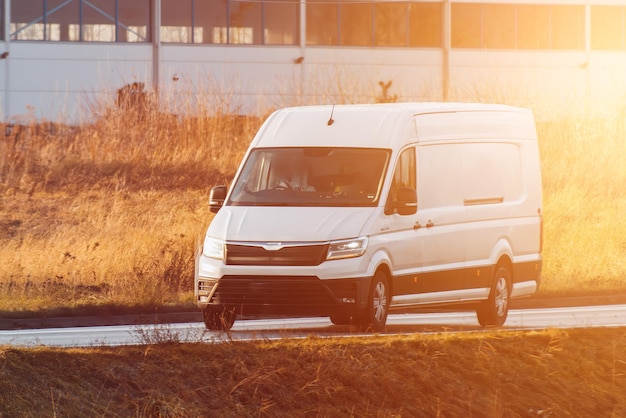 Una maqueta de una furgoneta blanca con un envoltorio vacío para personalizar Un vehículo comercial para su servicio de entrega y transporte Pequeño camión blanco aislado en la carretera