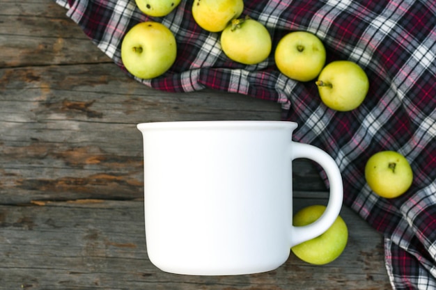 Maqueta de granja taza de café con leche y manzanas sobre fondo de madera natural