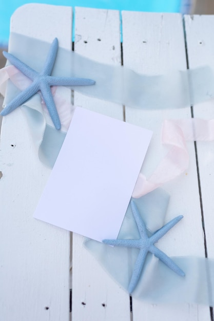 maqueta de hoja de papel sobre fondo de mar azul con estrellas de mar