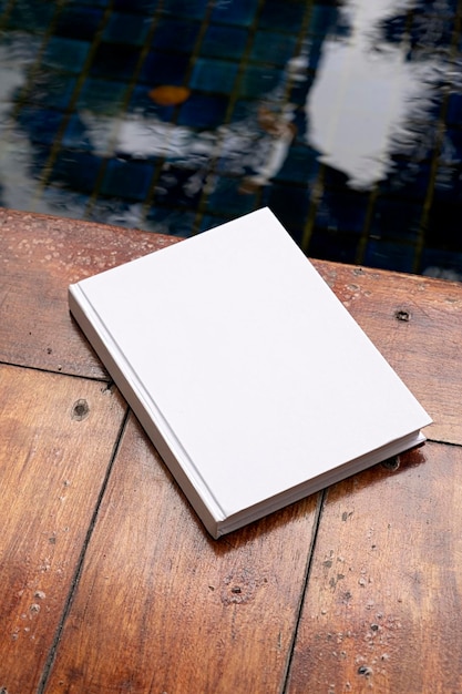 maqueta de libro en el suelo de madera cerca de la piscina o el estanque