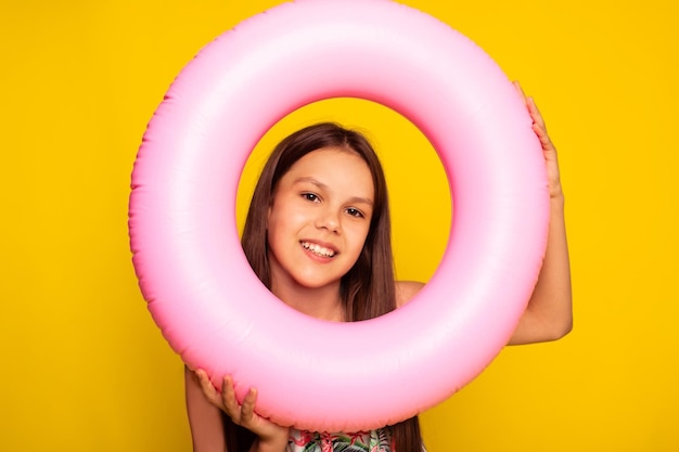 Foto maqueta de lugar de anillo inflable para logo chica adolescente mirando a la cámara sobre fondo amarillo