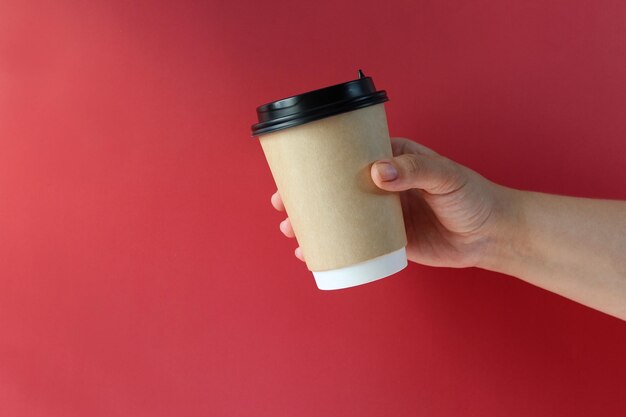 Maqueta de mano de mujer sosteniendo una taza de papel de café en el fondo Espacio de copia de vista frontal