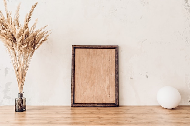 Maqueta de marco de madera en mesa de bambú para su obra de arte