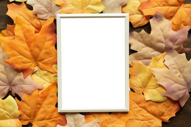 maqueta de marco de papel en blanco blanco con un grupo de fondo de hojas de arce de color naranja secas