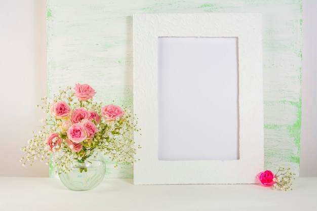 Maqueta de marco con rosas en florero de vidrio