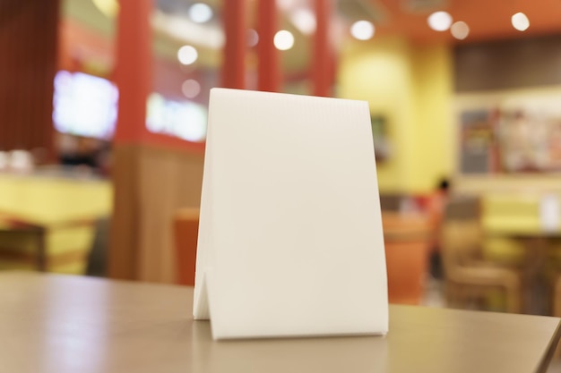 Foto maqueta de menú en blanco para promoción de marketing de texto maqueta de marco de menú de pie sobre una mesa de madera en el espacio del restaurante para texto