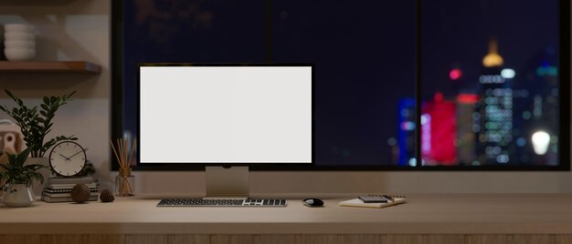 Foto una maqueta de monitor de computadora en un escritorio de madera contra la ventana con una vista de luz nocturna de la ciudad