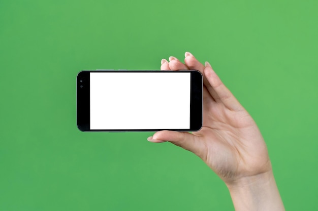 Maqueta móvil publicidad en línea tecnología de internet mano femenina sosteniendo teléfono inteligente con espacio en blanco