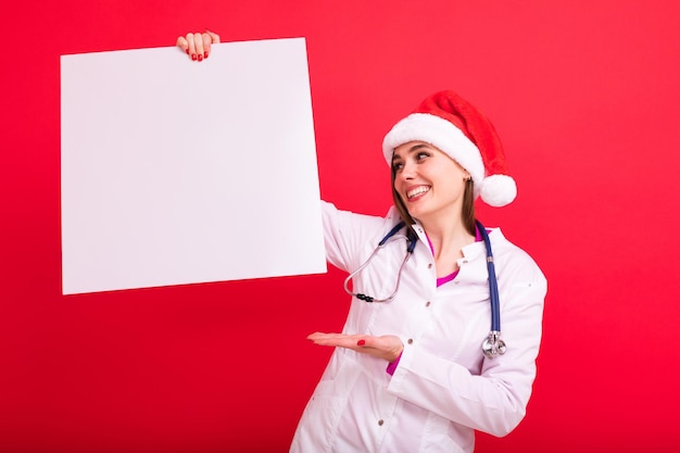 Maqueta de Navidad Enfermera con un cartel blanco sobre un fondo rojo