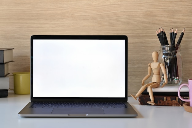 Maqueta de pantalla en blanco portátil y material de oficina en mesa blanca.