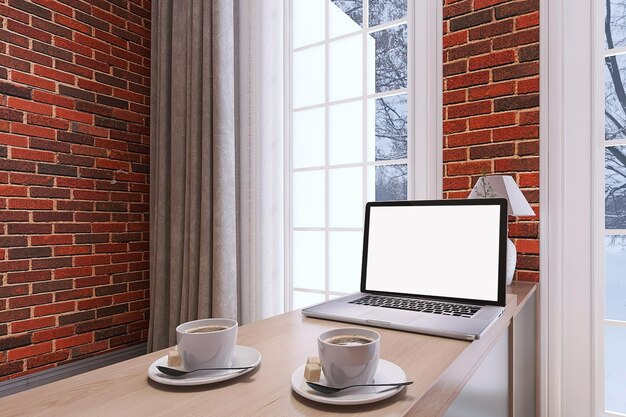 Maqueta de portátil en la mesa de la oficina con café contra el fondo de la pared de ladrillos