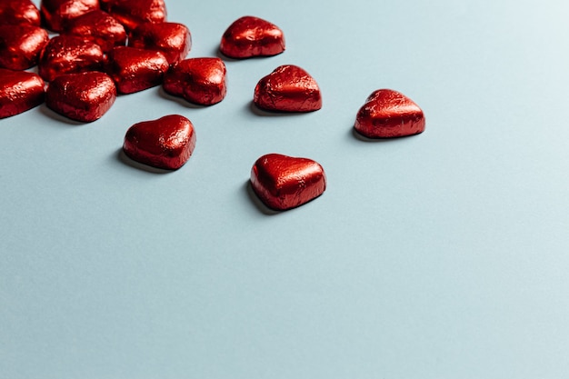 Una maqueta de San Valentín con coloridos corazones rojos sobre un fondo azul pastel para el día del amor con espacio de copia