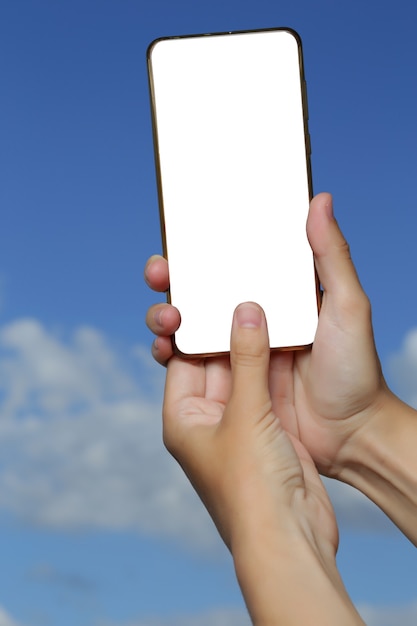 Maqueta de smartphone en una mano femenina contra un fondo de cielo azul