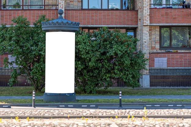 Maqueta de tablero de información pública en blanco al costado de la calle cerca de un edificio residencial