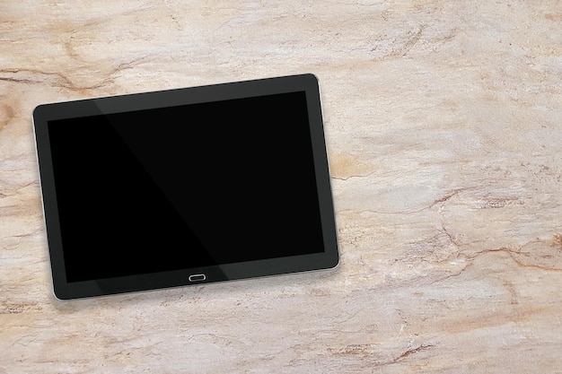 Maqueta de una tableta digital plateada negra moderna en un escritorio de mármol vista de ángel alto