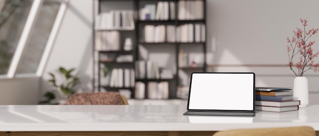 Maqueta de tableta en una mesa blanca sobre una sala de estar minimalista moderna y borrosa en el fondo