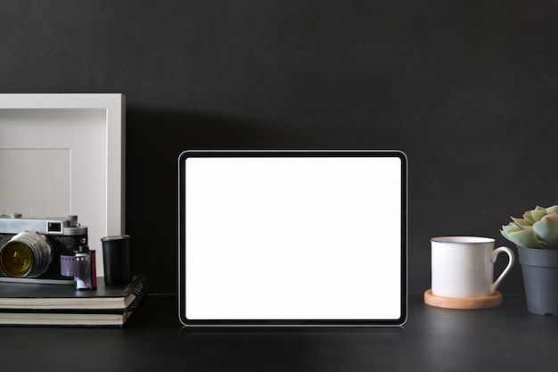 Maqueta de la tableta de pantalla en blanco en el área de trabajo del fotógrafo