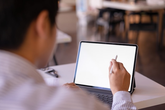 Maqueta tableta de pantalla de escritorio blanco en blanco con un hombre que trabaja. Tableta de pantalla blanca para montaje gráfico.