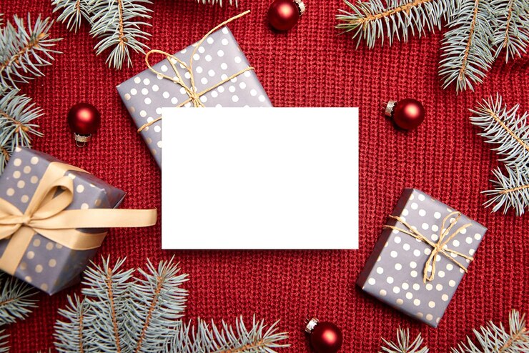 Maqueta de tarjeta de felicitación navideña, caja de regalo, ramas de abeto verde y adornos navideños en rojo