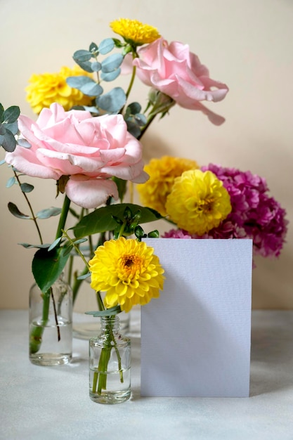 Maqueta de tarjeta de felicitación de papel blanco en blanco Flores rosas y amarillas en jarrones con espacio de copia Hydrangea dahlias y eucalipto