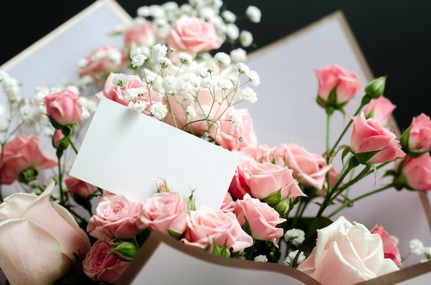 Maqueta de tarjeta de felicitación en un ramo de rosas rosadas, foto de primer plano