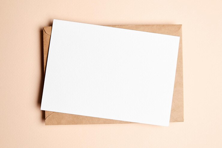 Maqueta de tarjeta de felicitación con sobre en fondo beige vista superior plana en blanco tarjeta de vacaciones o volante