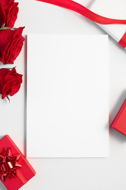 Maqueta de tarjeta navideña con plantilla de lista en blanco blanca Endecha plana con rosas rojas y vista superior de regalos