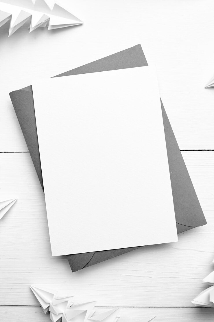 Maqueta de tarjeta navideña con sobre y abetos de papel blanco sobre fondo blanco de madera vista superior plana Maqueta de tarjeta de felicitación de Navidad con decoraciones