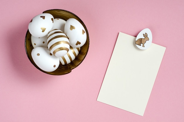 Maqueta de tarjeta de Pascua feliz con huevos sobre fondo rosa