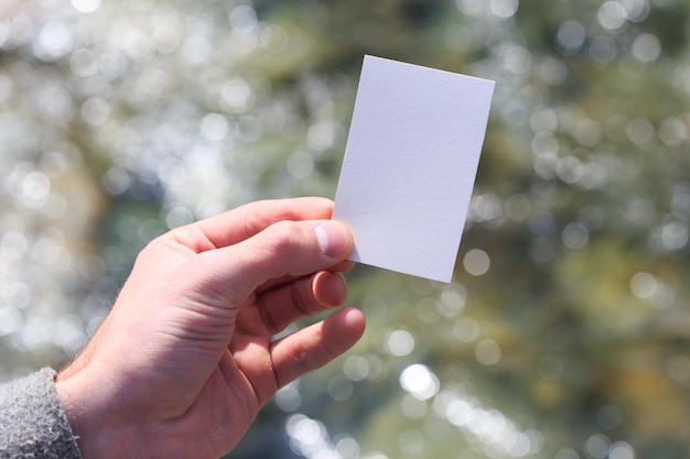 Maqueta de una tarjeta de presentación blanca en blanco en la mano de un muchin contra el fondo del agua Para el diseño de su tarjeta de presentación Branding Mock up