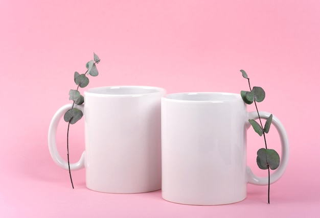 Maqueta taza de café blanco o taza en manos femeninas sobre fondo rosa con espacio de copia. Plantilla en blanco para su diseño, marca, negocio. Foto real