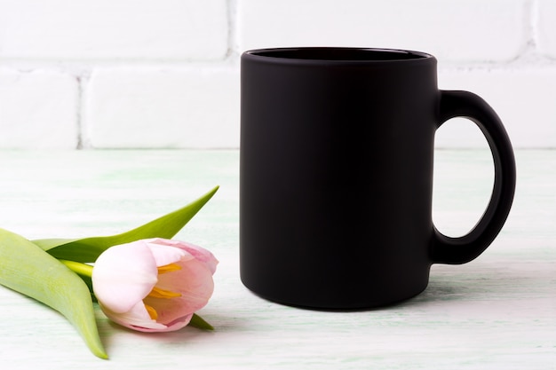 Maqueta taza de café negro con tulipán rosa