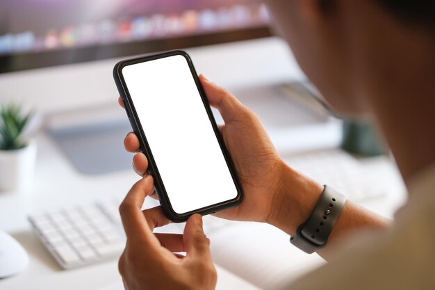 Maqueta de teléfono inteligente de mano sosteniendo un teléfono móvil negro con pantalla blanca en blanco