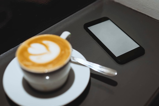 Maqueta de teléfono móvil con una taza de café