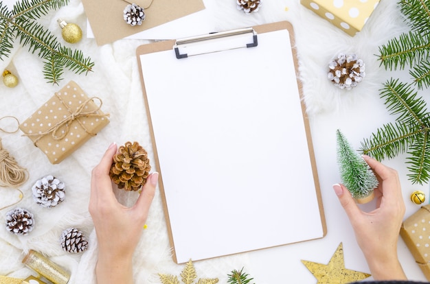 Maquete da área de transferência com uma decoração de natal. mulher segura, árvore natal