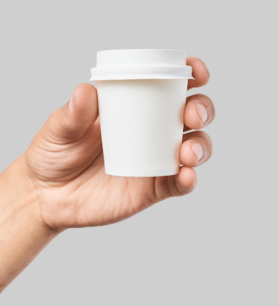 Maquete da mão masculina segurando uma xícara de café expresso de papel branco com tampa branca