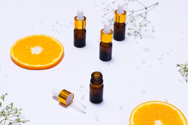 Maquete de branding. Óleo essencial natural, frascos de cosméticos com rodelas de laranja.