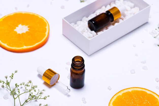 Maquete de branding. Óleo essencial natural, frascos de cosméticos com rodelas de laranja.