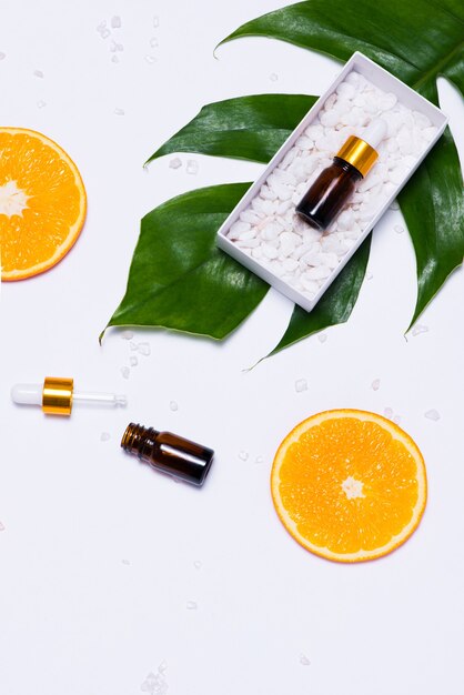 Maquete de branding. Óleo essencial natural, frascos de cosméticos com rodelas de laranja.