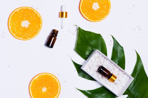 Maquete de branding. Óleo essencial natural, frascos de cosméticos com rodelas de laranja.