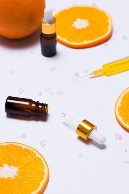 Maquete de branding. Óleo essencial natural, frascos de cosméticos com rodelas de laranja.